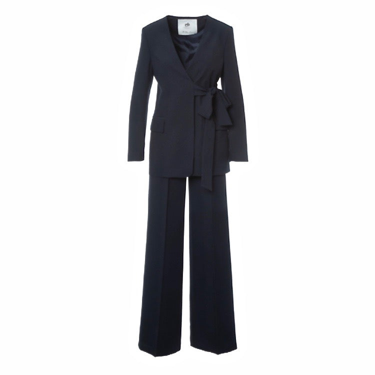 Donkerblauw pak met wijde pantalons en wikkeljasje.